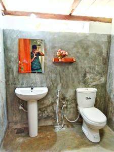 a bathroom with a toilet and a sink at Hiriketiya Green Hill Home in Dickwella