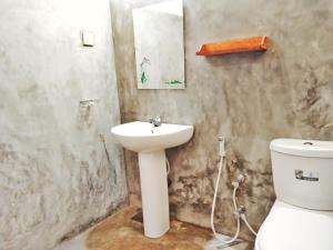 a bathroom with a sink and a toilet at Hiriketiya Green Hill Home in Dickwella