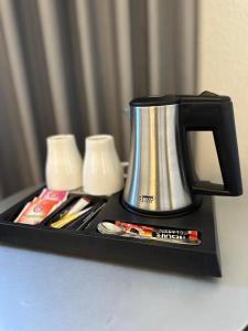 an Hotel في Selm: صينية سوداء مع وعاء القهوة وبعض الشموع