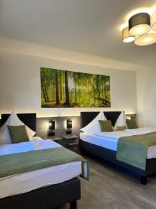 a hotel room with two beds and a painting on the wall at an Hotel in Selm