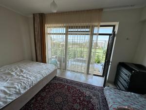 - une chambre avec un lit et une fenêtre avec un balcon dans l'établissement TownHouse in Baytur Resort&Spa 3 bedroom 92m2 Таунхаус, à Bosteri