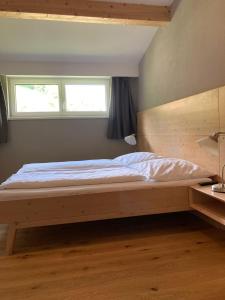 シュラートミンクにあるAppartement Hochfilzerのベッドルーム1室(木製ベッド1台、窓付)