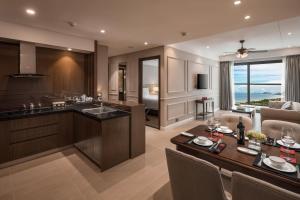 a kitchen and living room with a table and chairs at Beachfront Luxury Apartment - Rooftop pool - Da Nang in Danang