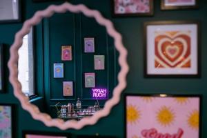 espejo en una habitación con una pared verde con fotografías en The Greeen Room, en Launceston