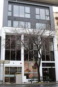 un edificio con un árbol delante de él en The Greeen Room, en Launceston