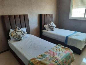 two beds in a small room with sidx sidx sidx at MAZAPART in El Jadida