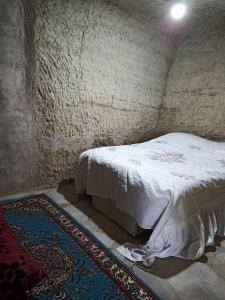 Kleines Zimmer mit einem Bett und einem Teppich in der Unterkunft KIR EVI/BAG EVI 