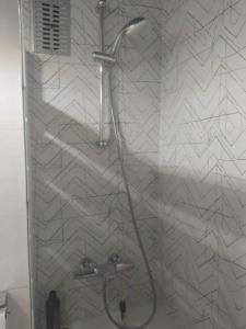 a shower with a shower head in a bathroom at Suite en apartartamento compartido en la playa a 20 minutos de Barcelona in Premiá de Mar