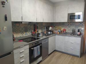 a kitchen with white cabinets and stainless steel appliances at Suite en apartartamento compartido en la playa a 20 minutos de Barcelona in Premiá de Mar
