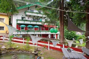 un edificio con adornos verdes y rojos con un estanque delante en Gletscherblick, 