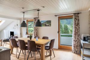 een keuken en eetkamer met een houten tafel en stoelen bij Gletscherblick 