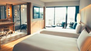 a hotel room with two beds and a bathroom at Southwest Grand Hotel in Naha