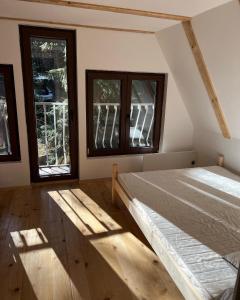een slaapkamer met 2 bedden en 2 ramen bij Tarushka house 
