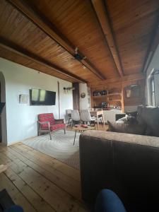 a living room with a couch and chairs and a tv at Tarushka house in Rača