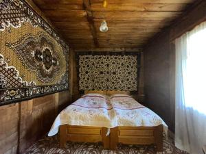 Schlafzimmer mit einem Bett mit dekorativer Wand in der Unterkunft Guest House Machakheli in Batumi