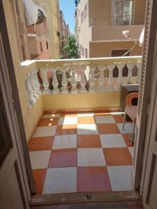 a room with a checkered floor and a balcony at Shery''s home in 6th Of October