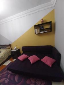 a bedroom with a black bed with pink pillows at Shery''s home in 6th Of October +5 photos