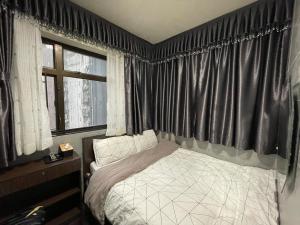 1 dormitorio con 1 cama y una ventana con cortinas en 香港美庭旅馆, en Hong Kong