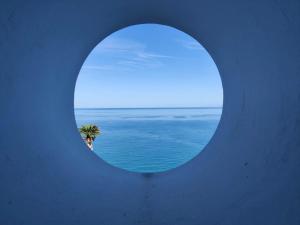 una finestra circolare con vista sull'oceano di B&B Casa Angelieri a Pizzo