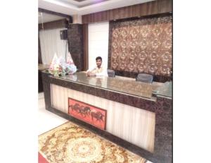 アラハバードにあるHotel Shree Urmila, Prayagrajのホテルロビーのカウンターに座る男