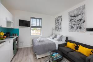 Una pequeña sala de estar con un sofá y una cocina. en Cosy Central Studio Apartment Zone 2 (4), en Londres