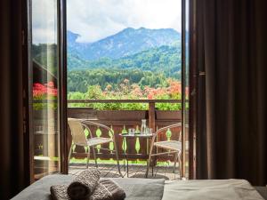 a bedroom with a balcony with a table and chairs at Jeff's - Rooms with a mountain view in Bad Goisern