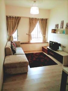 ein Wohnzimmer mit einem Sofa und einem TV in der Unterkunft Cozy Apartment 2 in Telipok Town