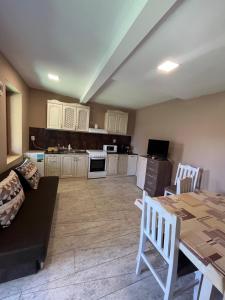 a living room with a table and a kitchen at Shabla Lux Guest Houses in Shabla