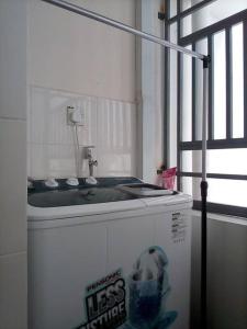 uma casa de banho com um lavatório e um frigorífico em Cozy Apartment 2 em Telipok Town