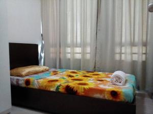 a bed with a colorful comforter in a bedroom at Cozy Apartment 2 in Telipok Town