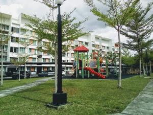 a playground in a park in front of a building at Cozy Apartment 2 in Telipok Town
