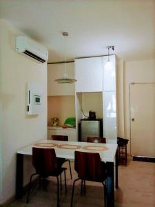 uma cozinha com mesa e cadeiras num quarto em Cozy Apartment 2 em Telipok Town