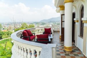 a balcony with chairs and a view of a city at The White House Villa 8 bedroom with Swimming Pool in Kathmandu
