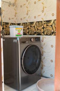 uma máquina de lavar roupa num quarto com papel de parede em The White House Villa 8 bedroom with Swimming Pool em Kathmandu