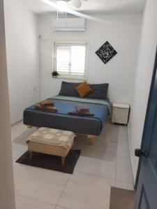 ein kleines Schlafzimmer mit einem Bett und einem Fenster in der Unterkunft Cozy 2-bedrooms with balcony 20 in Bat Yam