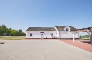 a white building with a pavilion in front of it at Arklių Pašto Stotis 