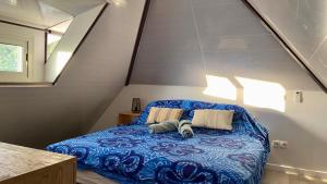 a bedroom with a blue bed with two pillows at Vanakea Beach House in Punaauia