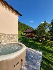 un jacuzzi en el patio trasero de una casa en Seoska kuća Rakić - Tara, en Rastište