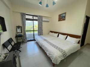 een slaapkamer met een groot bed en een raam bij Happy B&B in Yuli
