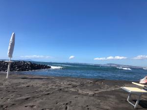 una playa con una silla y el océano en Sogno di mezza estate, en Torre Annunziata