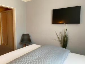 a bedroom with a bed with a flat screen tv on the wall at Weinhotel Römerbad in Bad Salzuflen