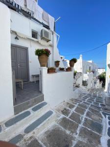 una casa con paredes blancas y una pasarela de piedra en Pensione Della Nonna, en Mykonos ciudad