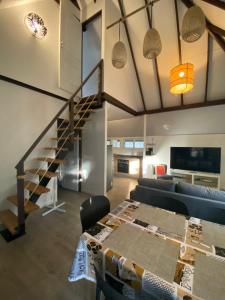 ein Wohnzimmer mit einer Treppe und einem Tisch in der Unterkunft Vanakea Beach House in Punaauia