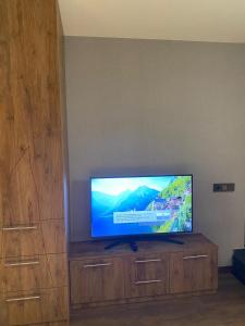 a flat screen tv sitting on top of a wooden entertainment center at Hotel Villa Niko Mari in Tbilisi City