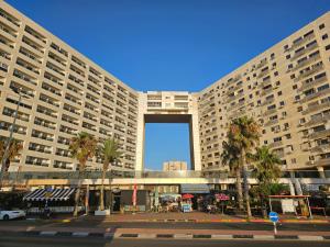 a large building with palm trees in front of it at Angel Apt-Amazing SeaView-Netfix-Wifi-Free Parking in Ashdod