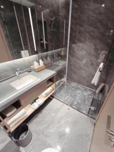 a bathroom with a sink and a shower at Shi Lai De Executive Apartments in Dongguan