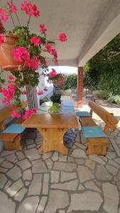 a picnic table and benches with flowers on a patio at Apartman CELIJA in Barban