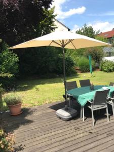 uma mesa com um guarda-chuva num deque em House with castle view & art em Günzburg