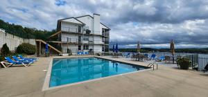 a house with a swimming pool in front of a building at AMAZING LAKE VIEW! GORGEOUS SUNSET! ON MAIN CHANNEL! 3BR/2BA-SLEEPS 6-8 in Lake Ozark