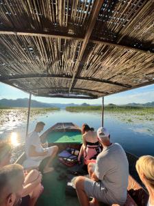Vranjina的住宿－Ethno village Moraca - Skadar lake，一群人坐在河边的船上